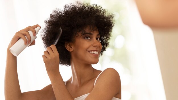 Medium shot smiley woman using hair product