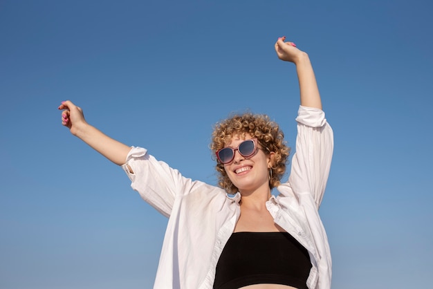 Medium shot smiley woman wearing sunglasses