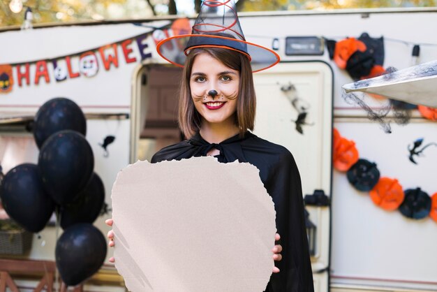 Medium shot smiley woman wearing witch hat