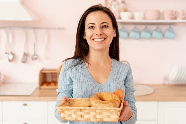 Medium shot smiley woman with basket of pastries