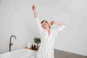 Free photo medium shot smiley woman with bathrobe