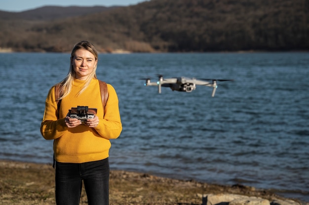 Free photo medium shot smiley woman with drone outdoors