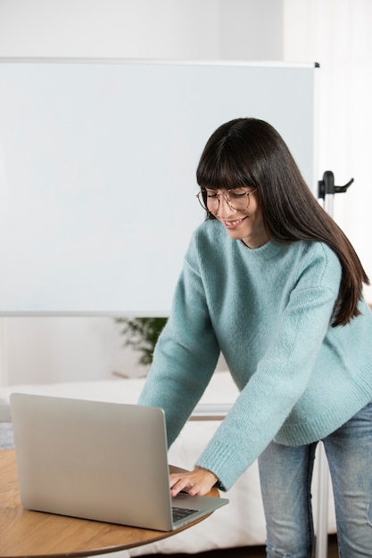 Medium shot smiley woman with laptop