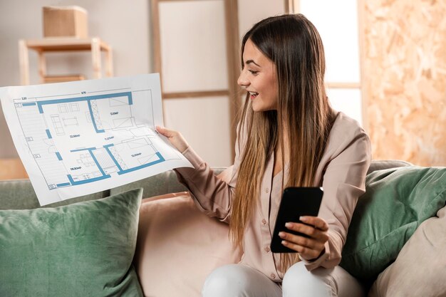 Medium shot smiley woman with phone and plan