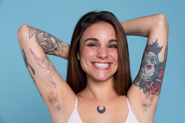 Free photo medium shot smiley woman with tattoos