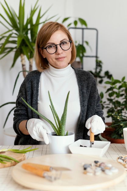 Free photo medium shot smiley woman working with gloves