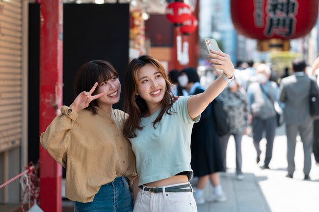 Medium shot smiley women taking selfie