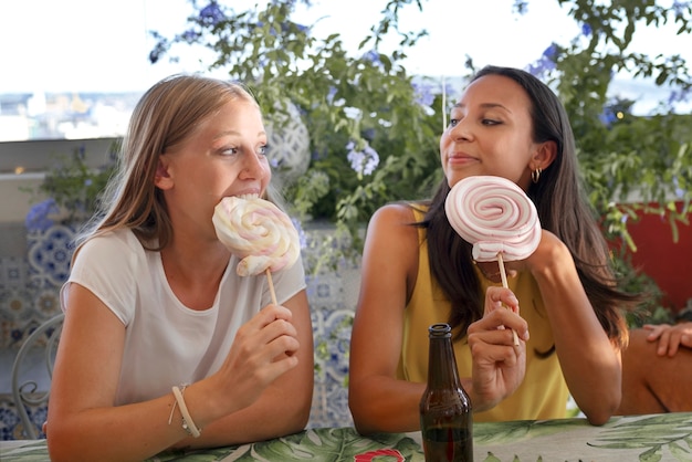 Free photo medium shot smiley women with candy