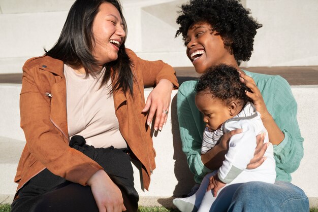 Medium shot smiley women with cute baby