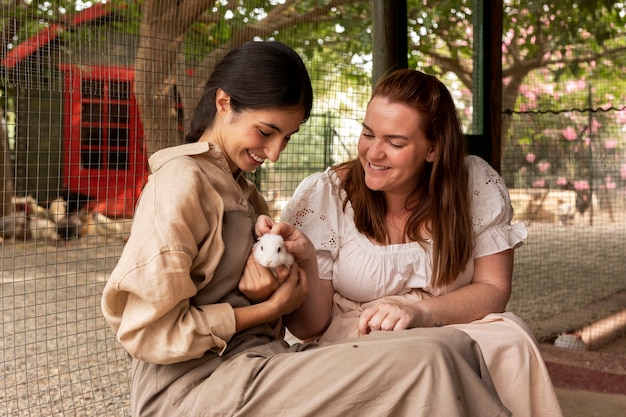 Free photo medium shot smiley women with cute rabbit