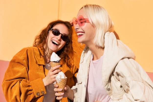 Free photo medium shot smiley women with ice cream