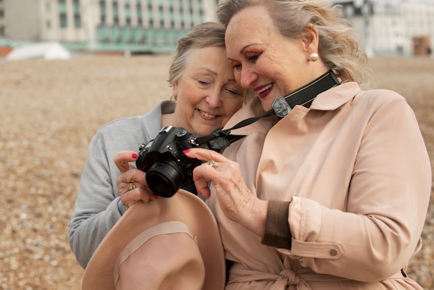 Free photo medium shot smiley women with photo camera