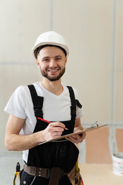 Free photo medium shot smiley worker wearing helmet