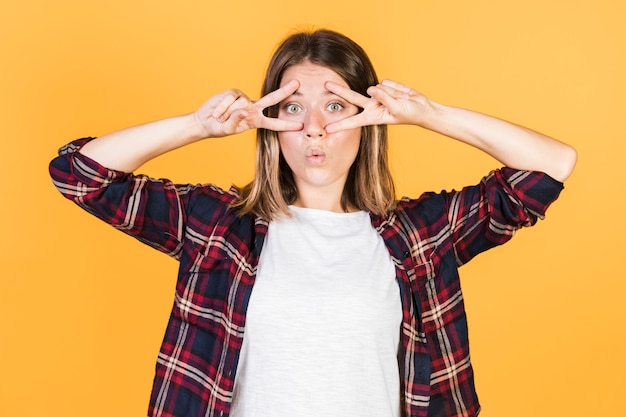 Free photo medium shot surprised girl doing peace sign