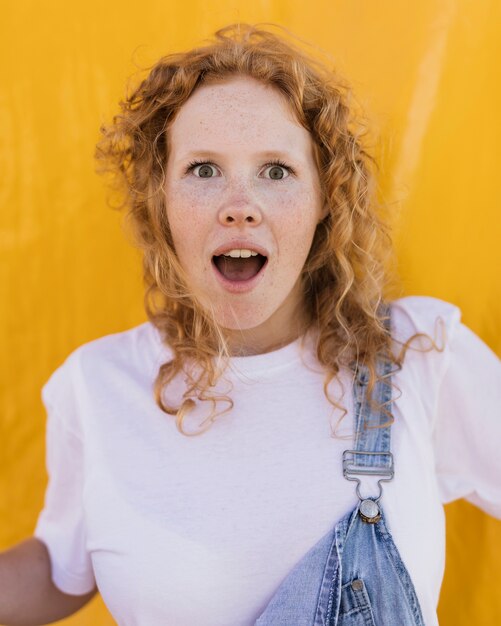 Medium shot surprised girl with yellow background