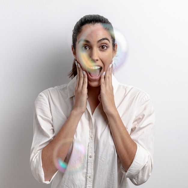 Medium shot surprised woman with soap balloons