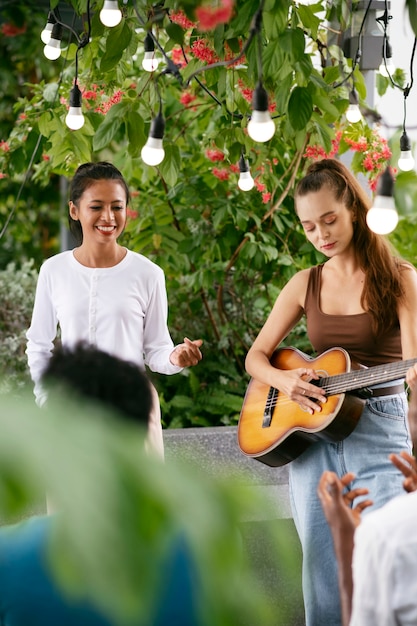 Medium shot talented woman playing the guitar