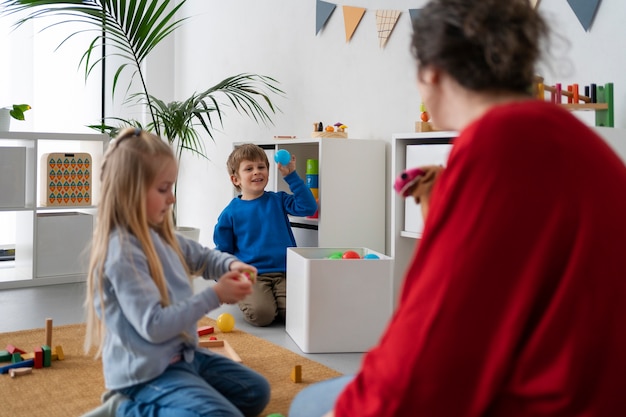 Medium shot teacher watching kids learn