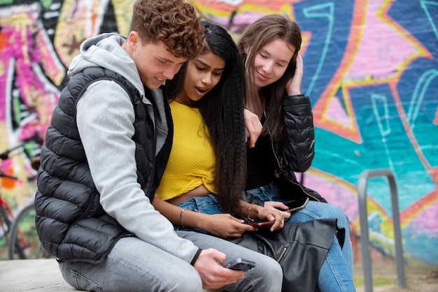 Medium shot teenagers with smartphones