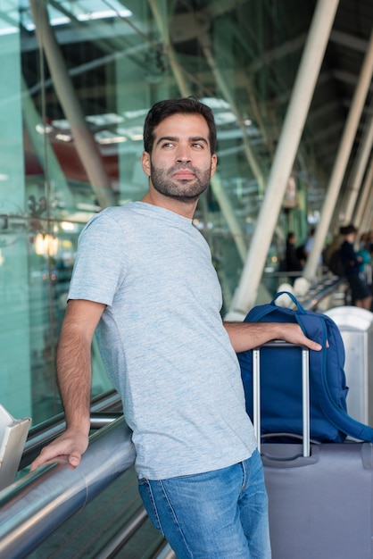 Free photo medium shot of thoughtful man leaning on railing at airport