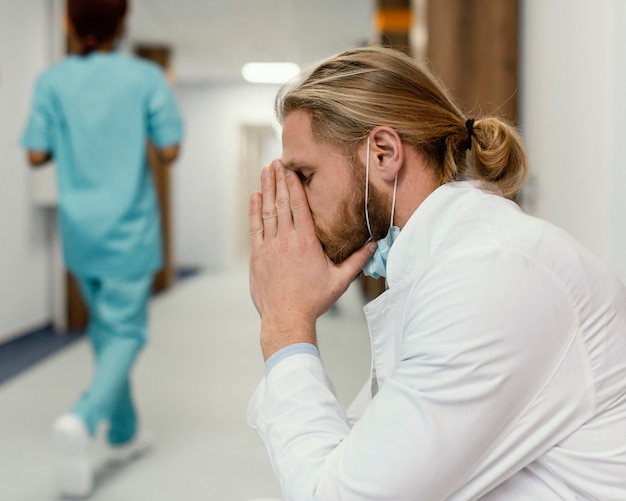 Free Photo medium shot tired doctor with mask