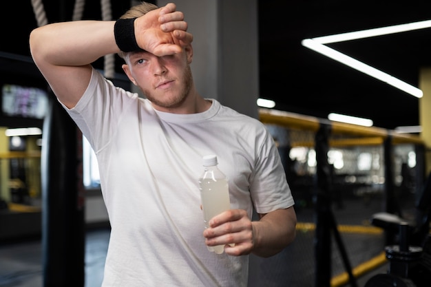 Medium shot tired man holding drink