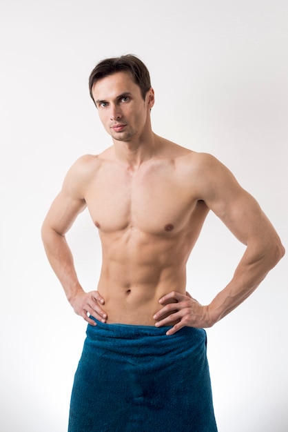 Medium shot topless man posing in bath towel