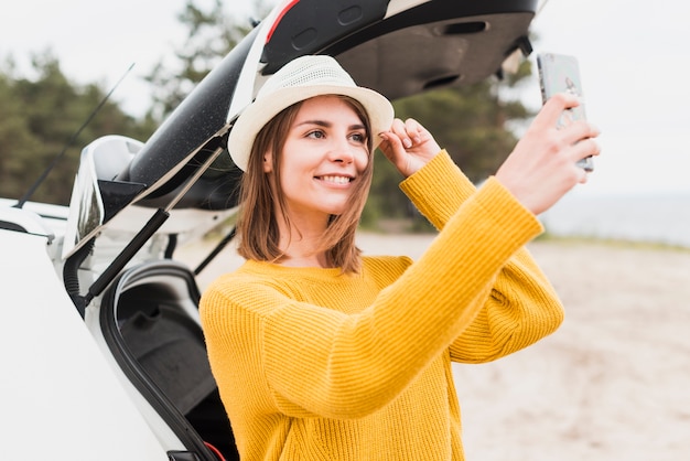 Medium shot of traveling woman taking a selfie