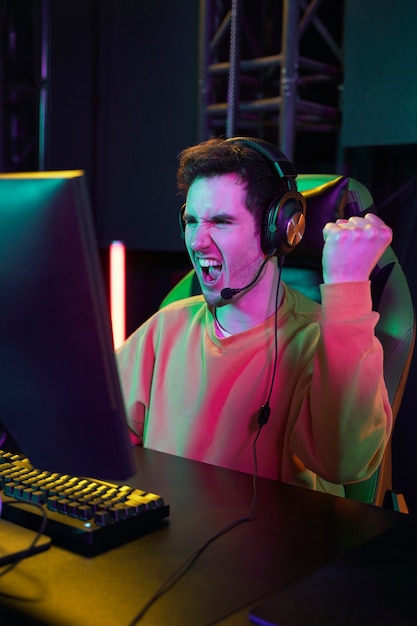 Free Photo medium shot victorious gamer at desk