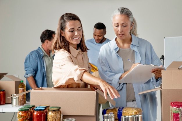 Medium shot volunteers with food donations