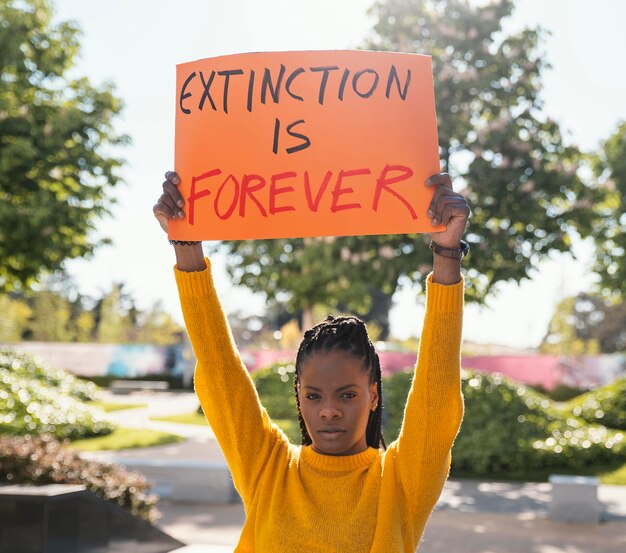 Medium shot woman activist holding placard