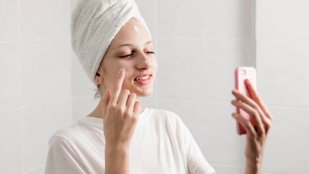 Medium shot woman applying cream