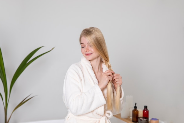 Medium shot woman braiding her hair