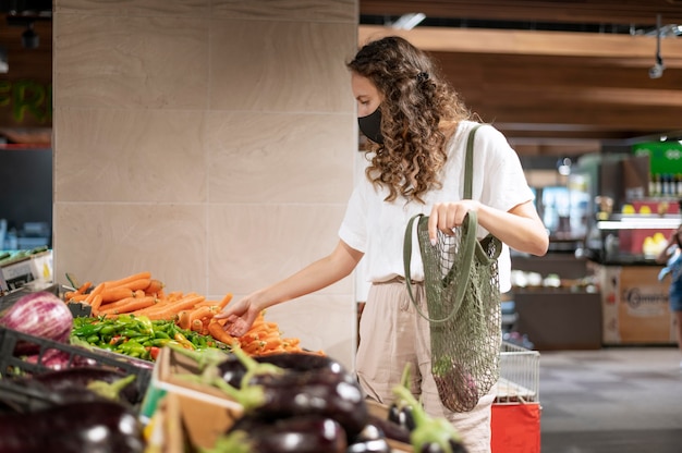 Free Photo medium shot woman buying vegetables