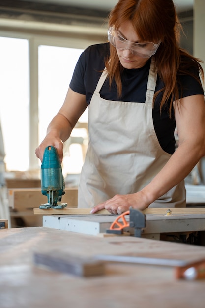 Free photo medium shot woman carpenter working in atelier