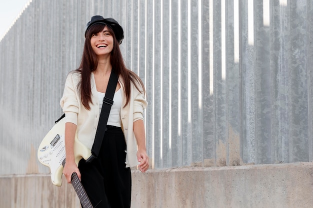 Free photo medium shot woman carrying guitar