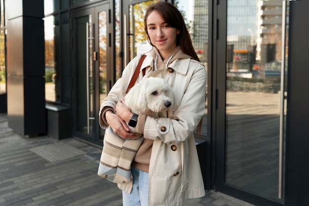 Free Photo medium shot woman carrying puppy in bag