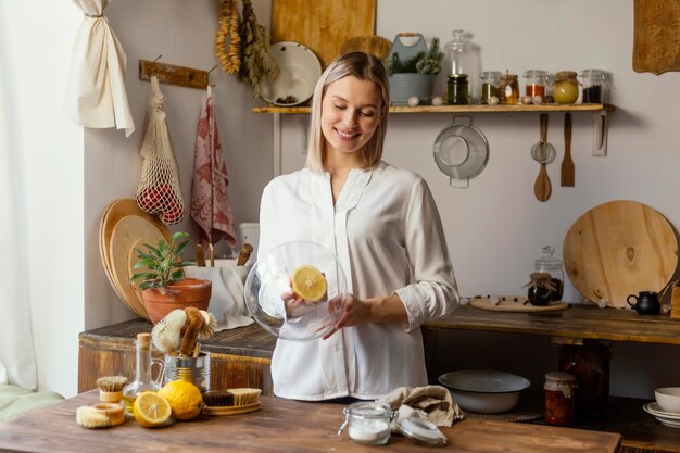 Medium shot woman cleaning with lemon