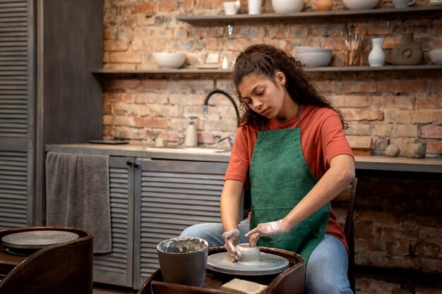 Medium shot woman doing pottery