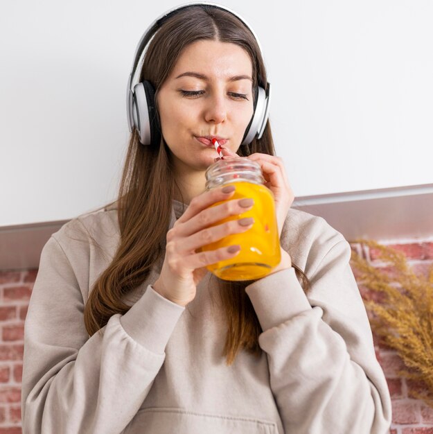 Medium shot woman drinking juice