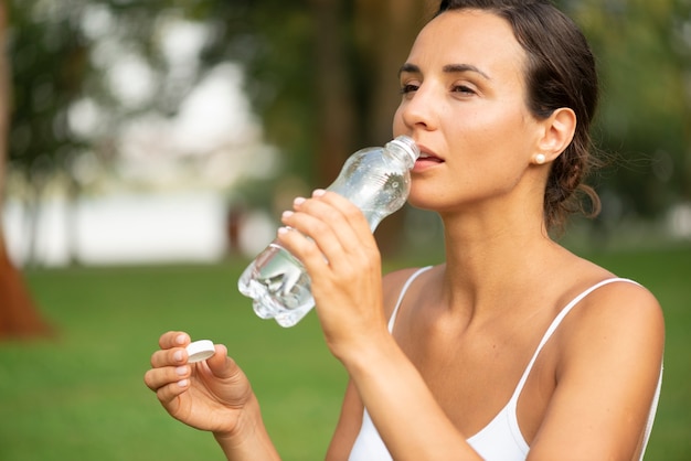 Free photo medium shot woman drinking water