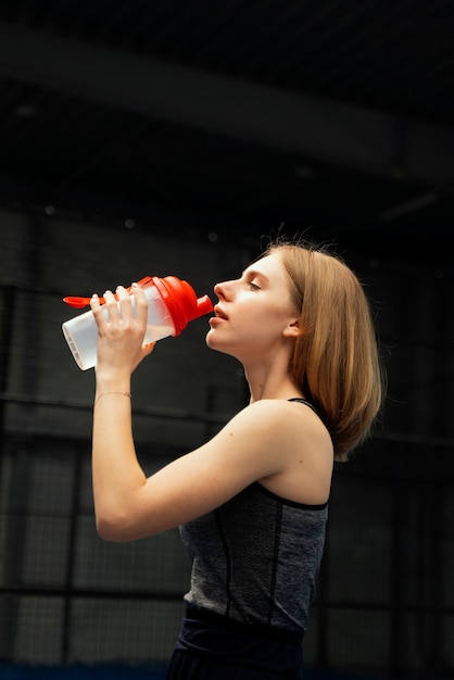 Free photo medium shot woman drinking water