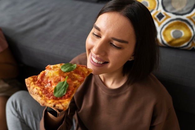 Medium shot woman eating delicious pizza