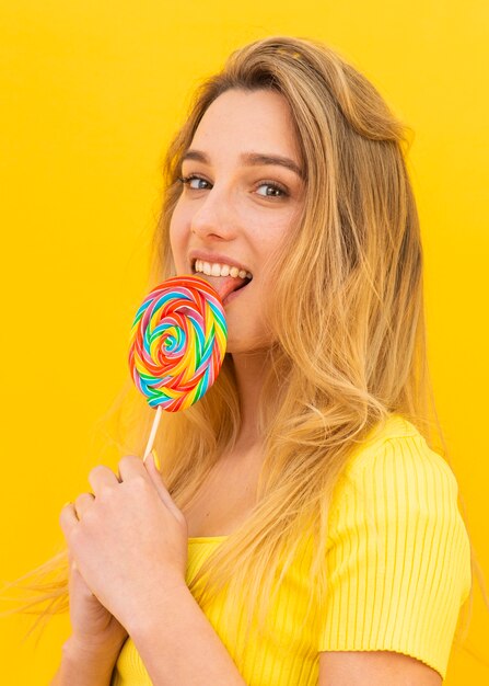 Medium shot woman eating lollipop