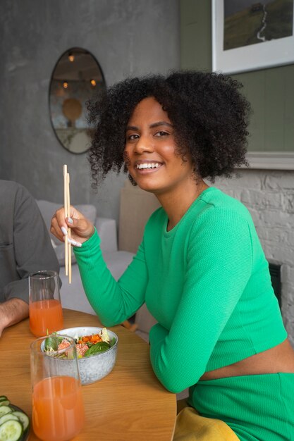 Medium shot woman eating salmon bowl