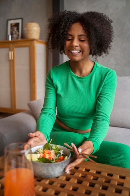 Medium shot woman eating salmon bowl