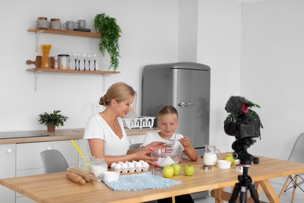 Free photo medium shot woman and girl cooking together