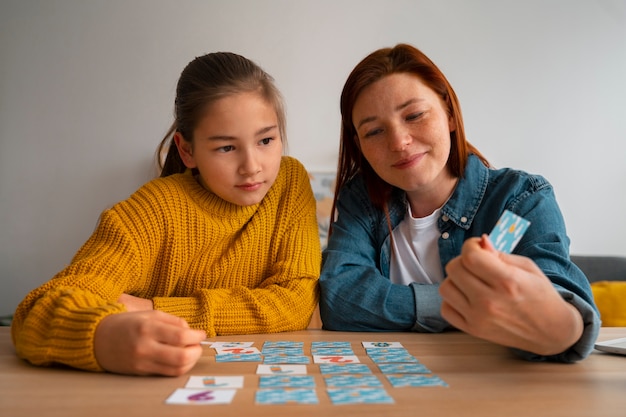 Free photo medium shot woman and girl playing memory game