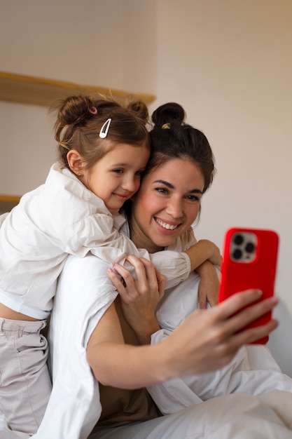 Free photo medium shot woman and girl taking selfie