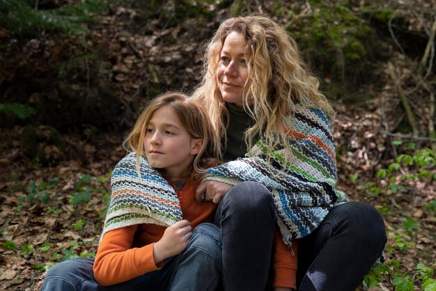 Medium shot woman and girl with blanket